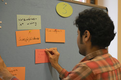 Brainstorming: Mann pinnt Karte an Pinnwand