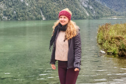 Eine Person steht auf einem Steg und lächelt in die Kamera.