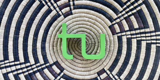 das TU Logo liegt auf einem Korb mit einem schwarz-braunen afrikanischenMuster