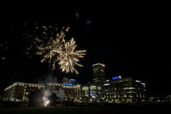Blick auf Gebäude bei Nacht und über dem Gebäude im Himmel ist ein Feuerwerk